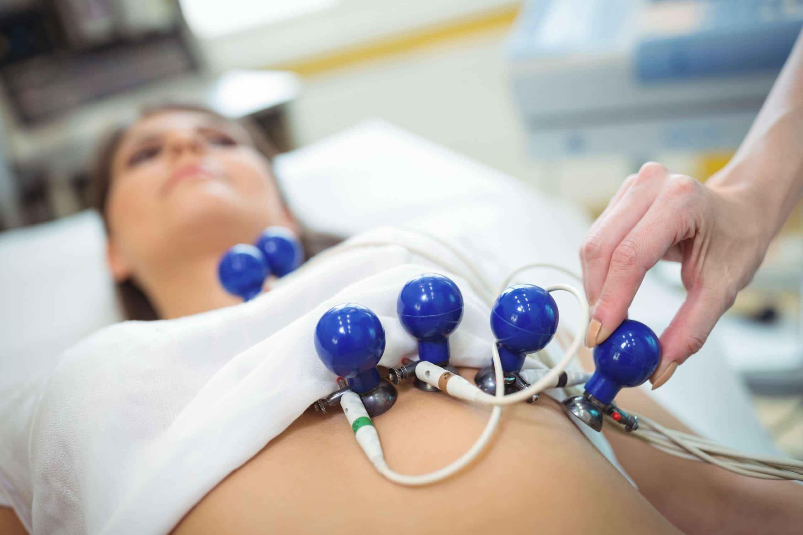 Doctors hand attaching sensors on the patient for electrocardiogram test
