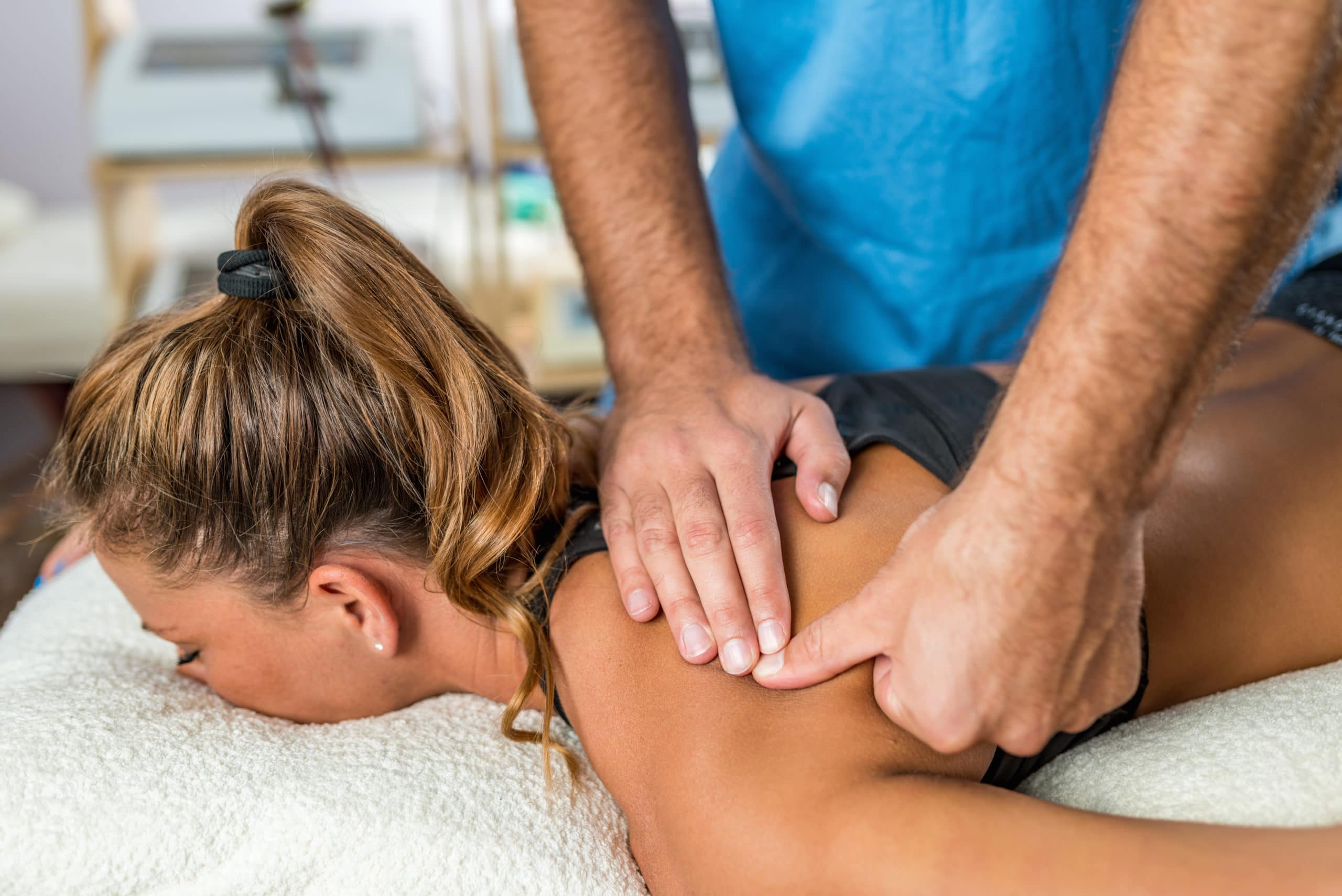 Osteopathy. Therapist applying strong pressure to shoulder muscles